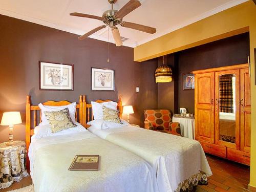 a bedroom with two beds and a ceiling fan at Raptor's Rest Bed and Breakfast in Empangeni