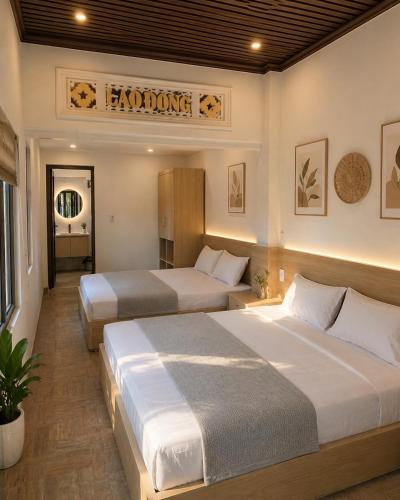 a hotel room with two beds and a sign on the wall at Pham's Homestay in Île de Trà Cổ