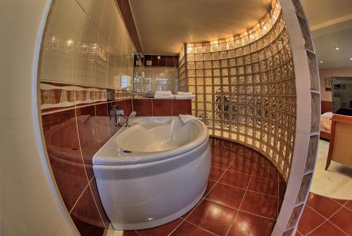 a bathroom with a tub and a sink at Hotel Polonia in Ostrów Wielkopolski