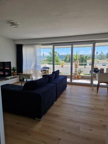 a living room with a blue couch and a large window at Offline by Alexa in Lahnstein