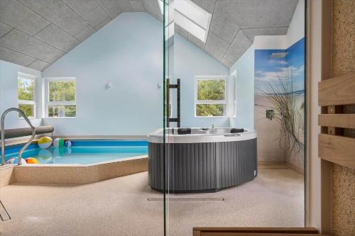 a bathroom with a tub and a swimming pool at 0498-Romo-Godthabsvej-29 in Høm