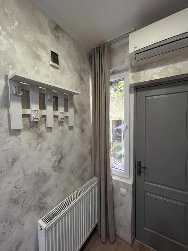 a hallway with marble walls and a door and a window at Hotel Maria in Tbilisi City