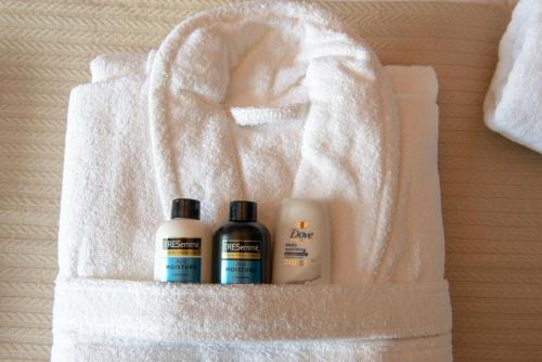 a white towel with three bottles of shampoo and conditioner at Three Eagles Hotel&Restaurant and Garden Bar in Llangollen