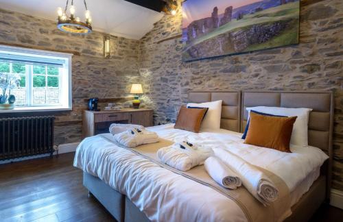 a bedroom with a large bed with towels on it at Three Eagles Hotel&Restaurant and Garden Bar in Llangollen
