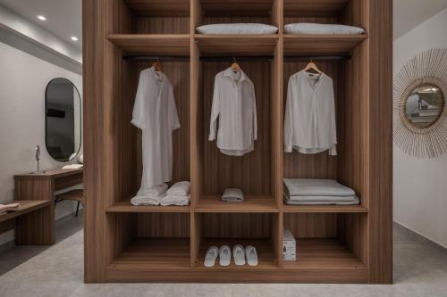 a wooden wardrobe with white clothes and towels at Kassandra Villas in Hanioti