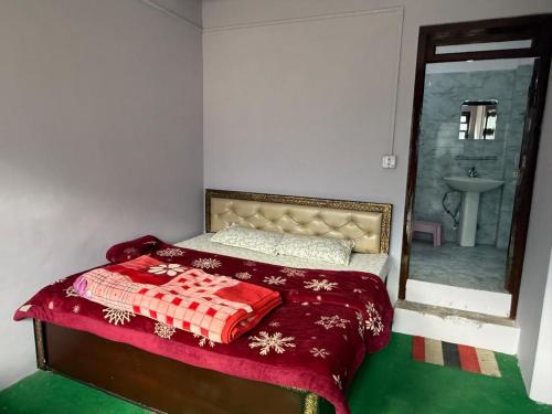 a bedroom with a bed with a red blanket and a mirror at Rock View in Kulu