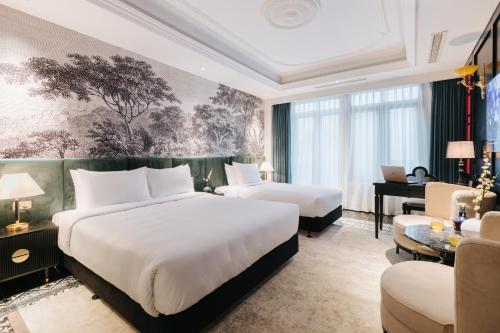 a hotel room with two beds and a desk at Brilliant Jade Suites in Hanoi