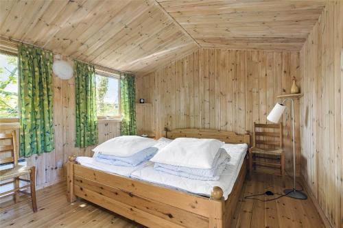 a bedroom with a bed in a wooden room at 13318-Asnaes-Lindevej-10 in Asnæs