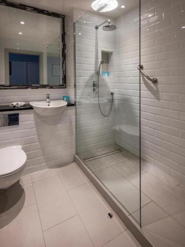 a bathroom with a shower and a toilet and a sink at Treacys West County Conference and Leisure Centre in Ennis