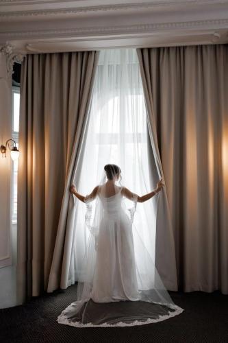 a woman is standing in front of a window at Modern Art Hotel - Maestro in Lviv