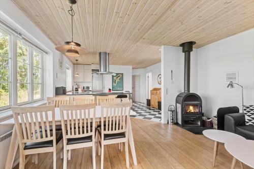 a kitchen and living room with a table and a fireplace at 0163-Romo-Havnebyvej-5 in Høm