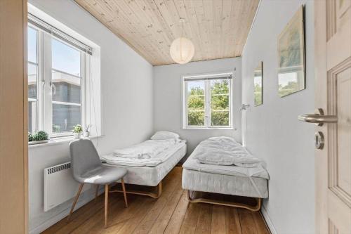 a room with two beds and a chair in it at 0163-Romo-Havnebyvej-5 in Høm