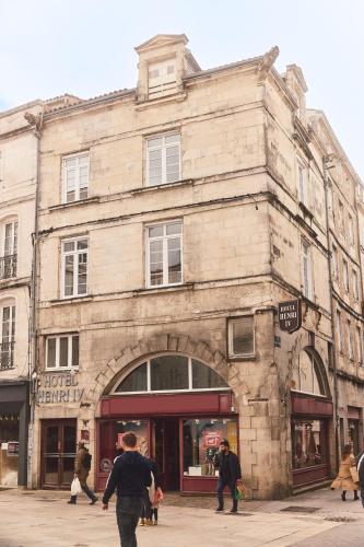 an old stone building with people walking in front of it at Hôtel Henri IV in La Rochelle