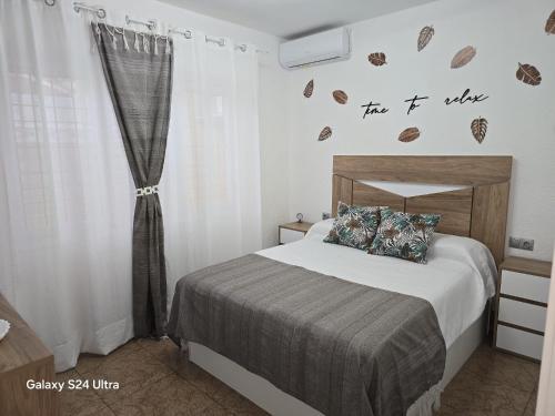 a bedroom with a bed with a sign on the wall at Villa Flores in Alicante