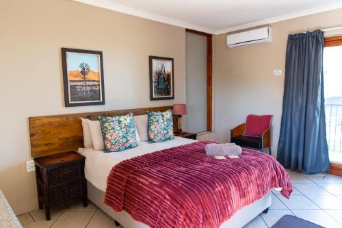 a bedroom with a bed with a red blanket at Piketberg Guesthouse in Piketberg