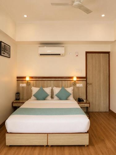 a bedroom with a large bed with blue pillows at May Fair in Mandi