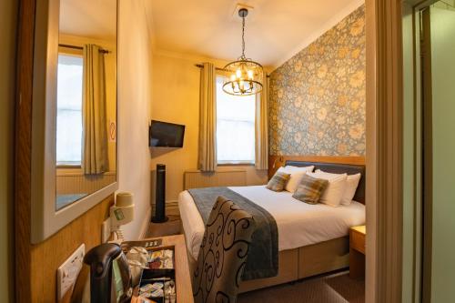 a hotel room with a bed and a window at The Goddard Arms in Swindon