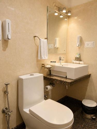 a bathroom with a white toilet and a sink at May Fair in Mandi
