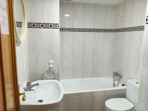 a bathroom with a sink and a tub and a toilet at Edificio Mirasierra in Oropesa del Mar