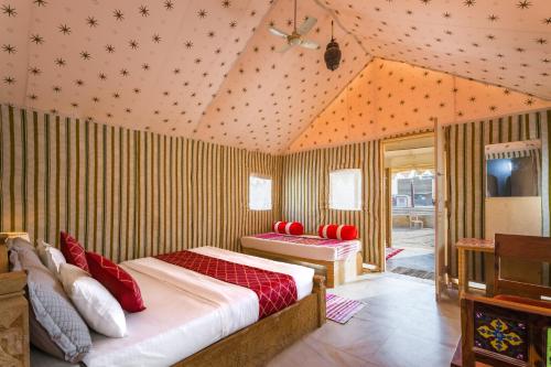 a bedroom with two beds with red pillows at Rojani Resort in Sām