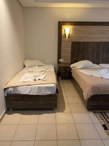 a bedroom with two beds with towels on them at Hôtel Matous in Tunis