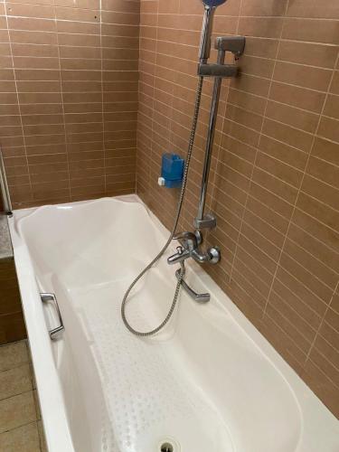 a bath tub with a faucet in a bathroom at Hôtel Matous in Tunis