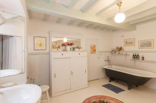 a bathroom with a black tub and a sink at Villa Il Rossignolo con Piscina in Grassina