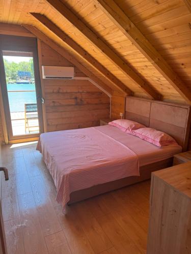 a bedroom with a large bed in a attic at Ada Bojana Kucica in Ulcinj