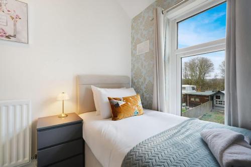 a bedroom with a bed and a large window at Work Friendly 3 Bed House with Sofa Beds that Sleeps 7 in Fishburn