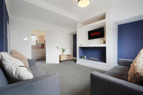 a living room with a couch and a tv at Work Friendly 3 Bed House with Sofa Beds that Sleeps 7 in Fishburn