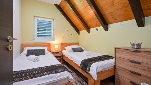 a bedroom with two beds and a dresser and a window at Villa Exclusive by Villas Guide in Lepoglava