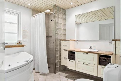 a bathroom with a tub and a toilet and a sink at LF584-Hurup-Thy-Haettemagevej-4 in Sindrup
