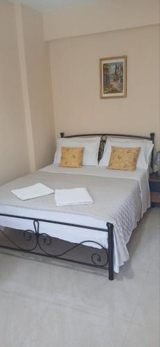 a bed with white sheets and pillows in a room at ARGOSTOLI sunset in Argostoli