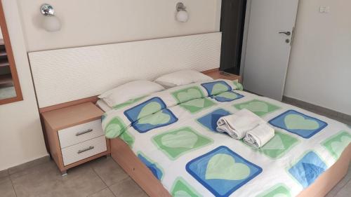 a small bedroom with a bed with colorful sheets and towels at Herzliya Center Apartments in Herzliya