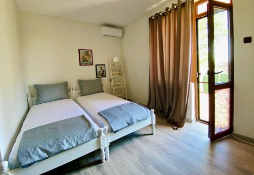 a bedroom with a bed and a large window at Нашата къща in Sinemorets
