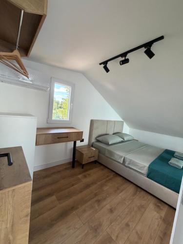a small bedroom with a bed and a desk at Buna riverfront in Ulcinj
