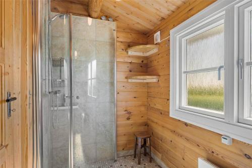a shower in a log cabin with a window at LF609-Hurup-Thy-Bakkesiden-9 in Doverodde