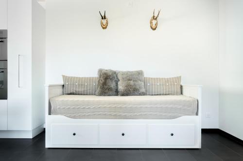 a white bed with two pillows on top of it at White Apartment in Andermatt