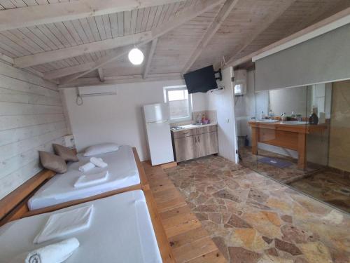 a large room with a kitchen and a refrigerator at White house in Donji Štoj