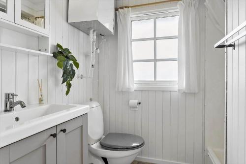 a bathroom with a toilet and a sink and a window at LF622-Hurup-Bakkesiden-22 in Hurup