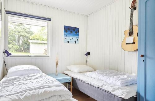 a bedroom with two beds and a guitar on the wall at 13365-Asnaes-Radyrvej-63 in Asnæs