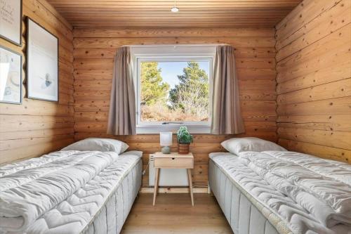 two beds in a room with a window at 0132-Romo-Kap-Farvel-12 in Høm
