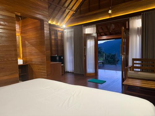 a bedroom with a bed and a door to a balcony at Bukit Kembang Sari in Bugbug