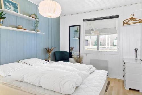 a large white bed in a room with a chair at LF15233-Hojslev-Jelsevej-261 in Højslev