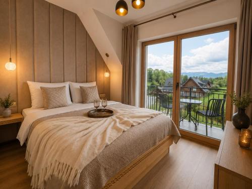 a bedroom with a large bed and a large window at Golden Trio Villas in Ząb