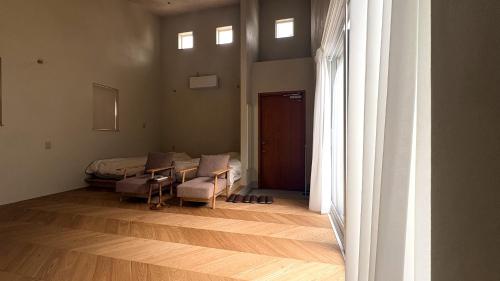 a room with a bed and a table and chairs at トシマトビ in Toshima