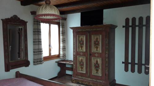 a bedroom with a wooden cabinet and a window at Hotel Bären Bern-Neuenegg Self-Check-In in Neuenegg