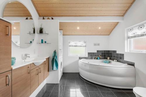 a bathroom with a large white tub and a sink at LF15149-Farso-Ramshule-49 in Farsø