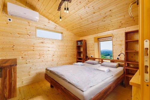a bedroom with a bed in a wooden cabin at Glamping Slavica in Dramlje