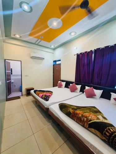 two beds in a room with a ceiling at Aasha Palace Khatu Shyam Ji in Khātu